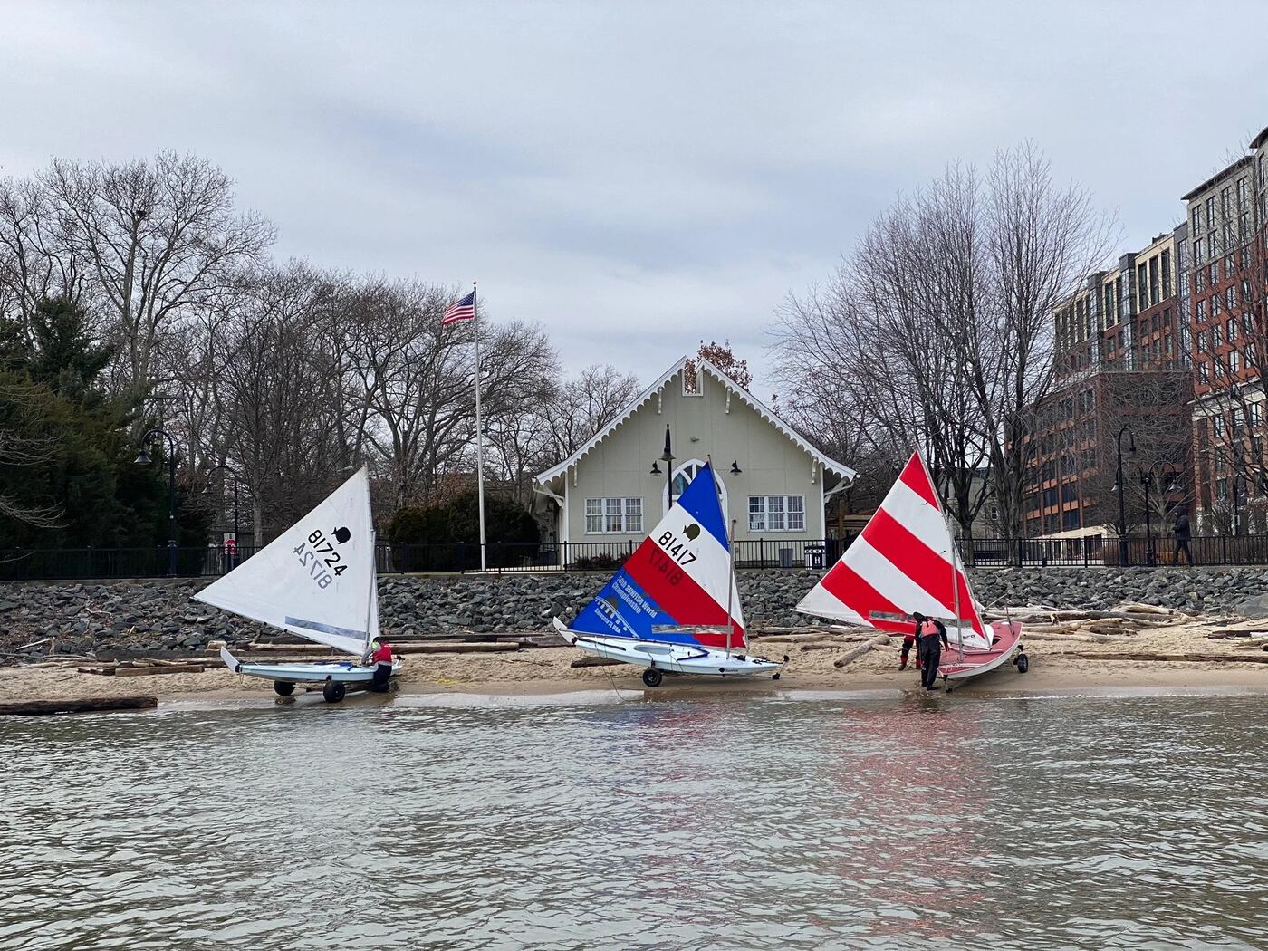 Sunfish sailboats on the cove beach in front of the boathouse