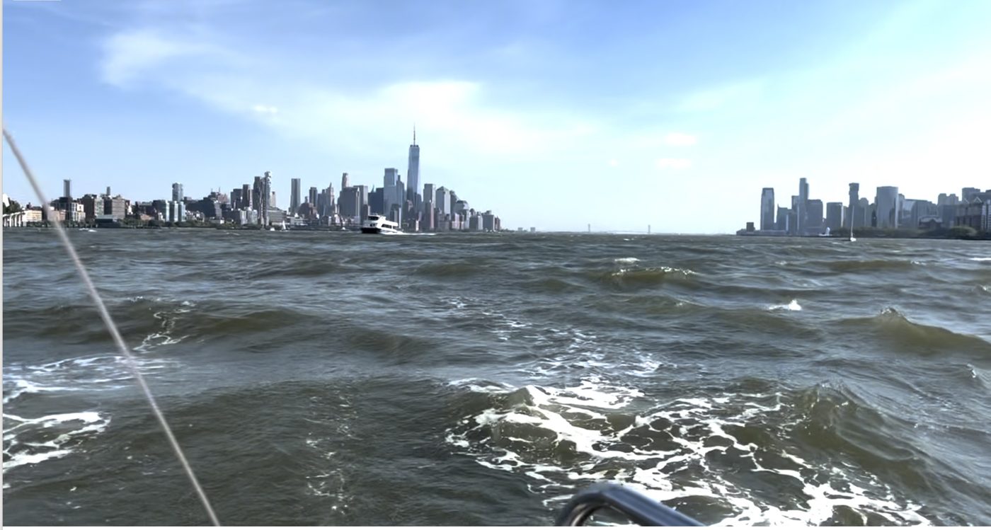 Wind chop on the Hudson seen from a boat, with the Lower Manhattan skyline on the horizon under a cloudy sky